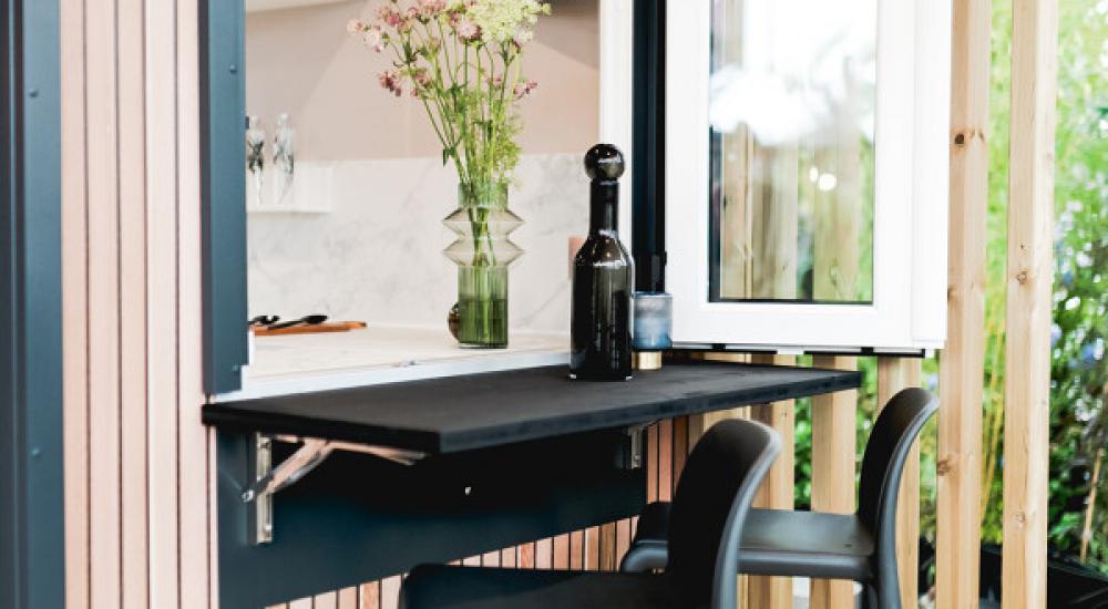 Une terrasse intégrée, dotée d'une ouverture avec bar reliant directement la cuisine et l'extérieur.